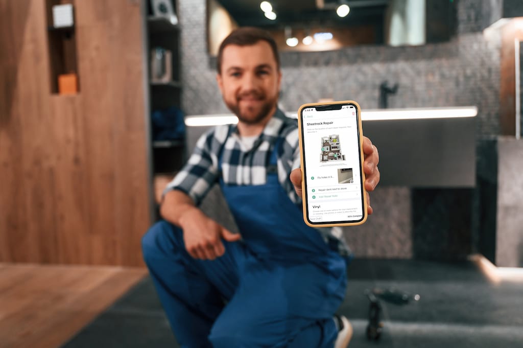 A property maintenance tech using a cell phone to manage a work order and inspection. 