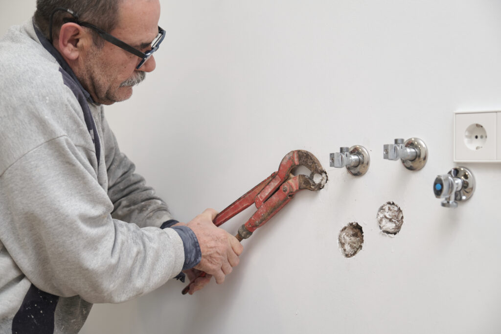 An experienced plumber completes a property maintenance task. 