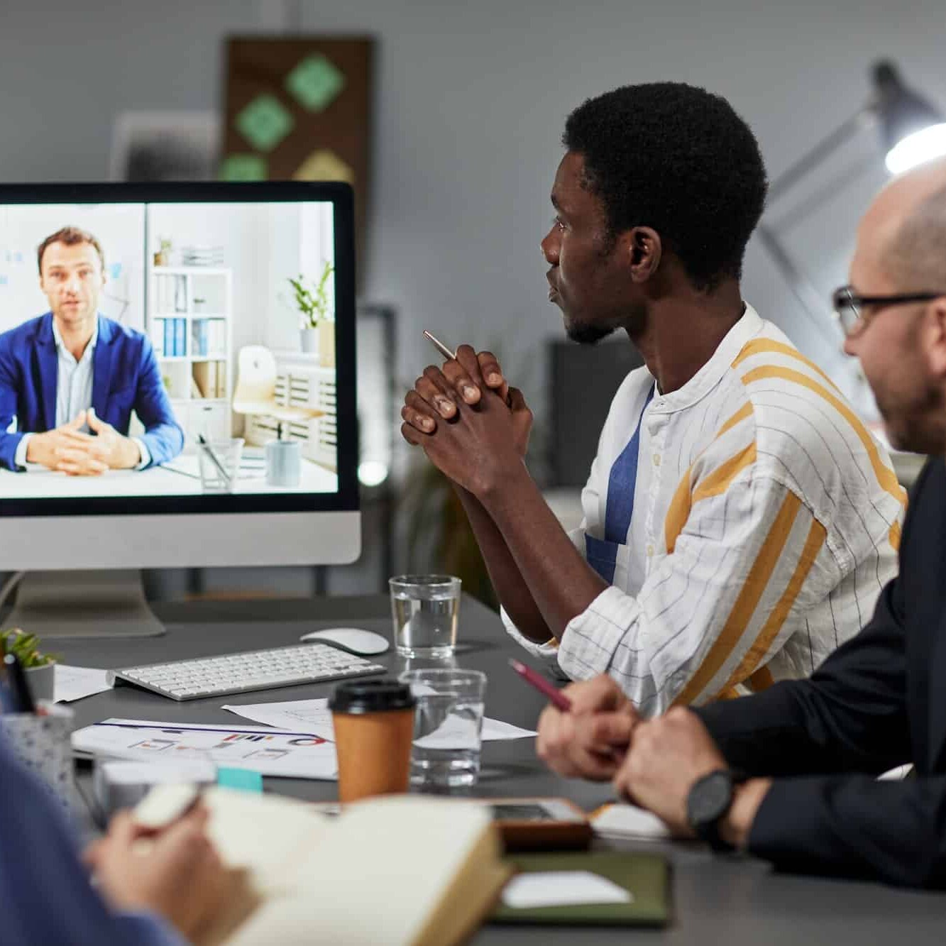 Property management employees working together and meeting with a colleague by videoconference