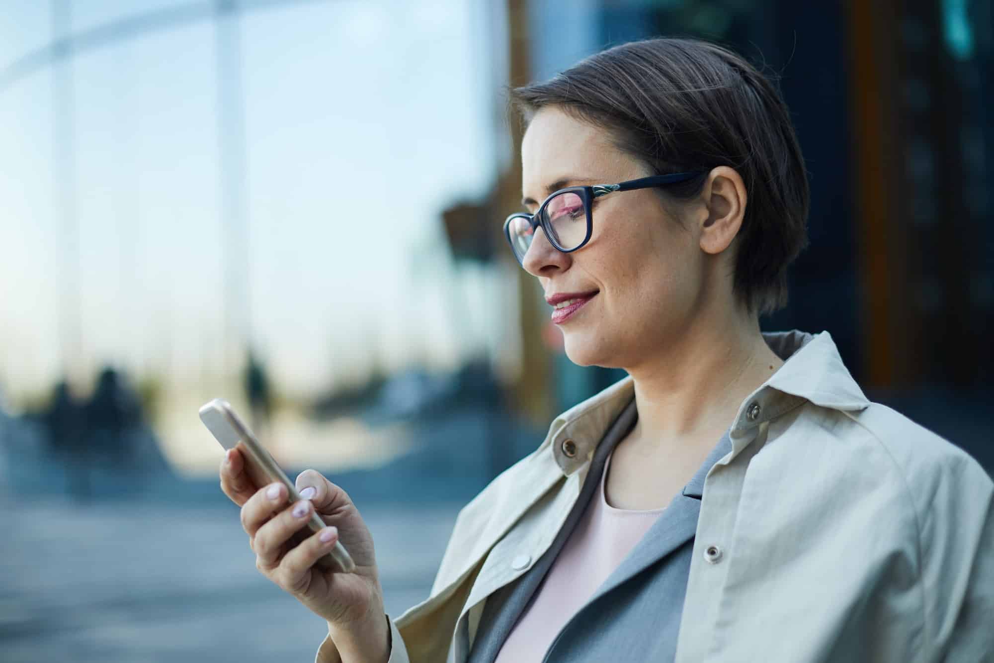 Woman looking at phone with maintenance app for apartments