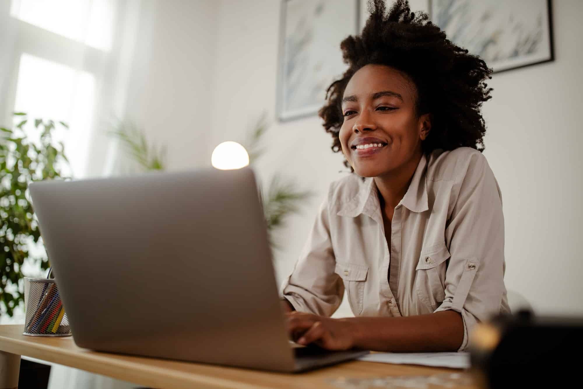 Black woman working on laptop in property management company office